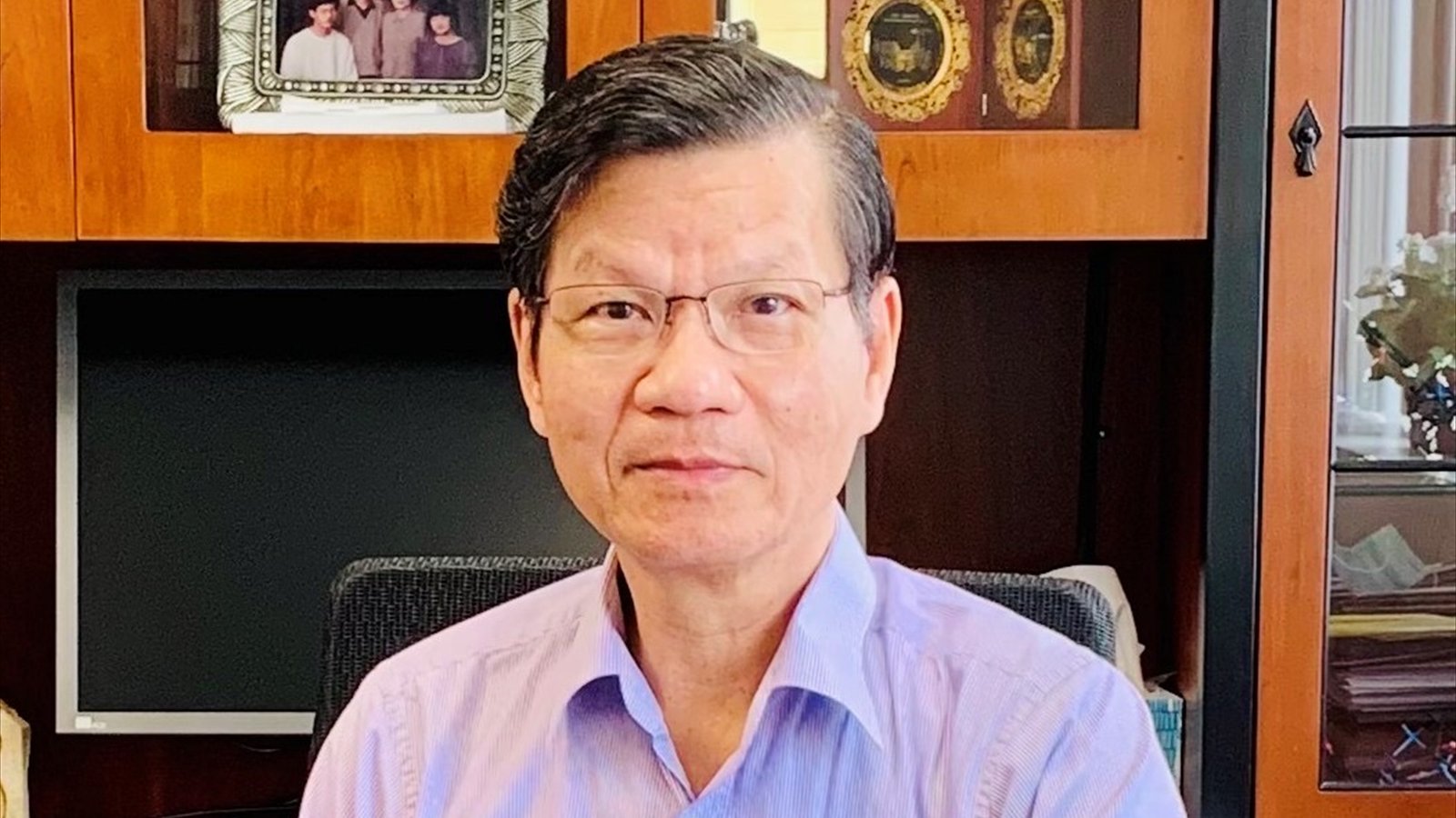 Chemist Chi-Huey Wong faces the camera in glasses and a pale purple shirt while seated in an office.
