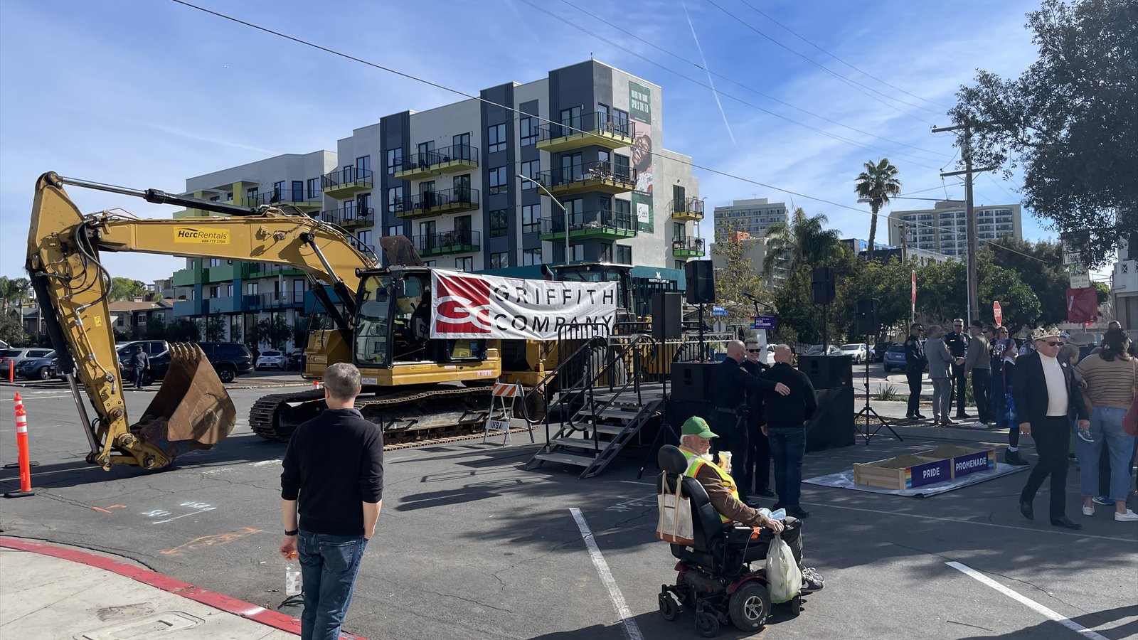 People gather beside ceremonial sand boxes and construction signs on Normal Street in Hillcrest.
