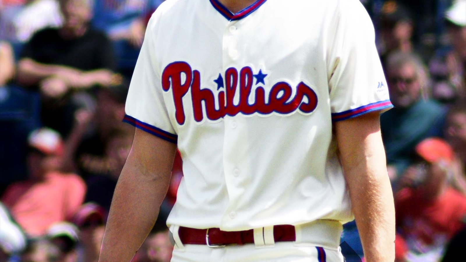 Nick Pivetta stands on a baseball field in a white Philadelphia Phillies uniform, cropped from his shoulders to his waist.