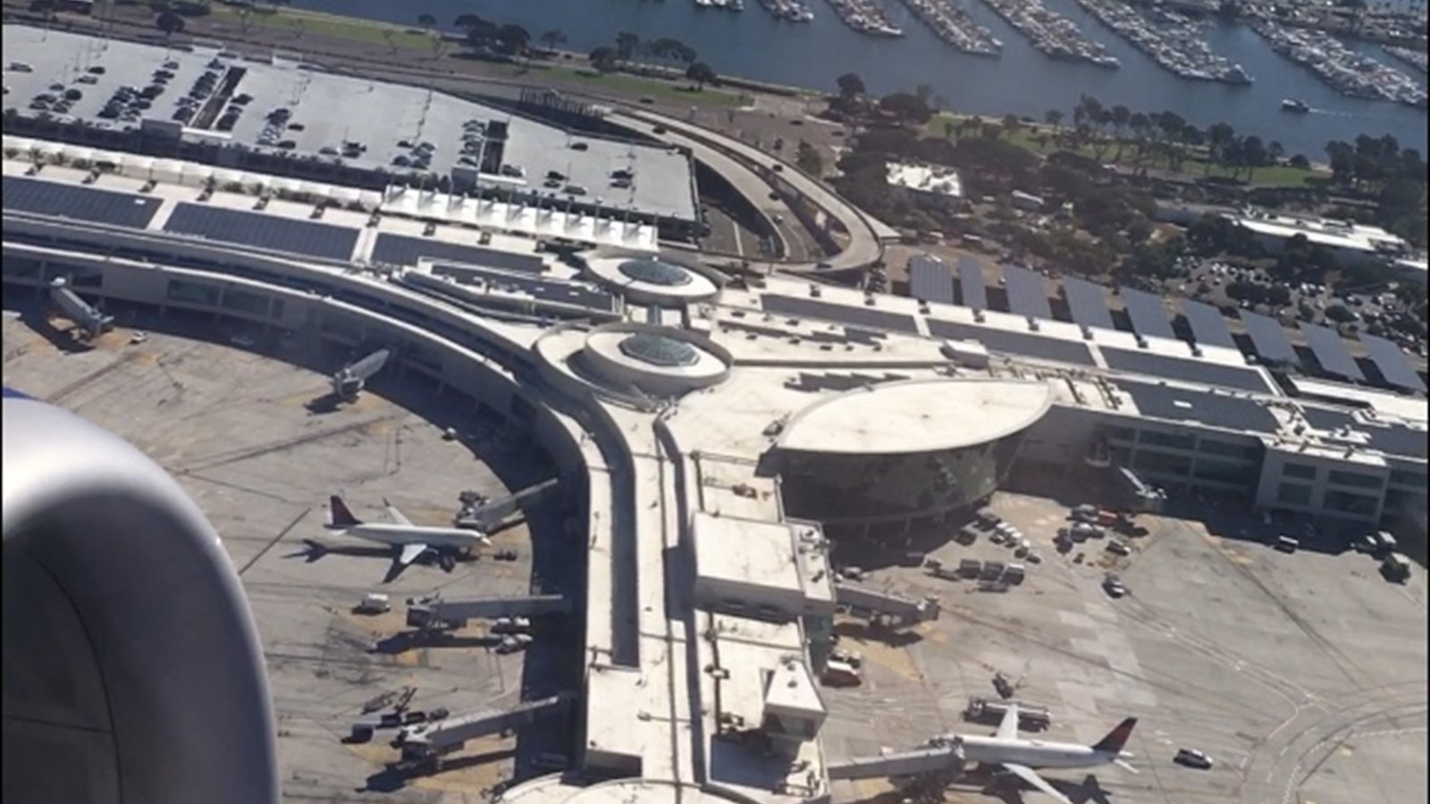 An aerial view of San Diego International Airport, its runway, terminals and nearby waterfront.
