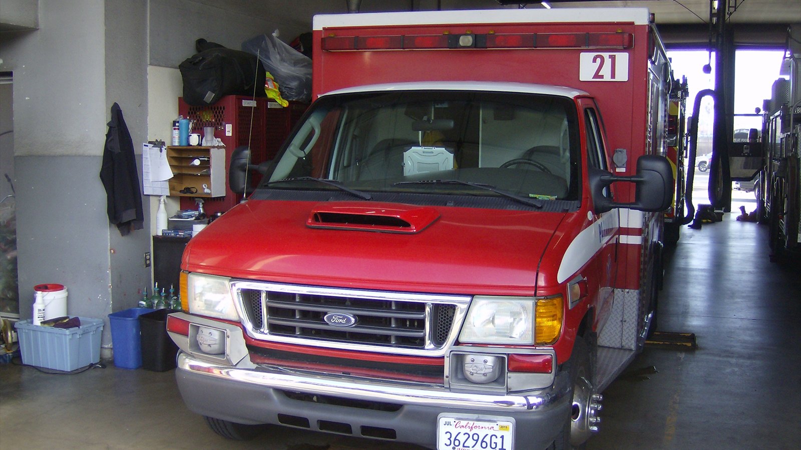 A red San Diego Fire-Rescue ambulance parked inside a station bay.