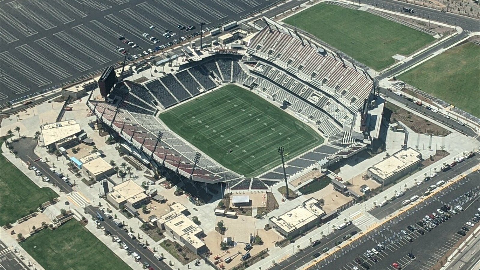 An aerial view looks down into Snapdragon Stadium and across its surrounding Mission Valley parking lots.
