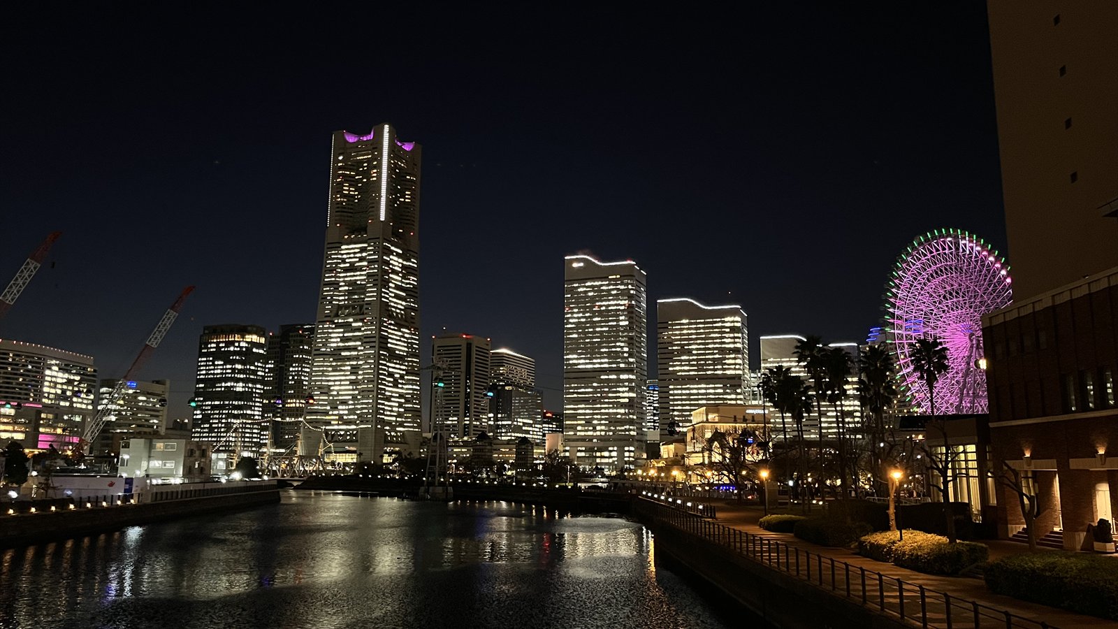 Yokohama's Minato Mirai skyline glows at night beside the dark waterfront.