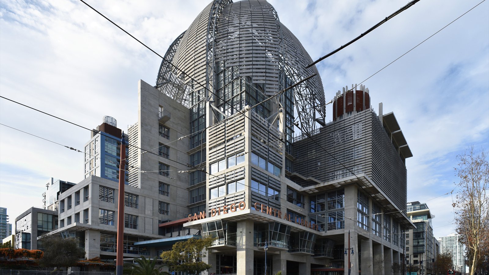 The San Diego Central Library entrance and metal lattice dome rise above a paved plaza.