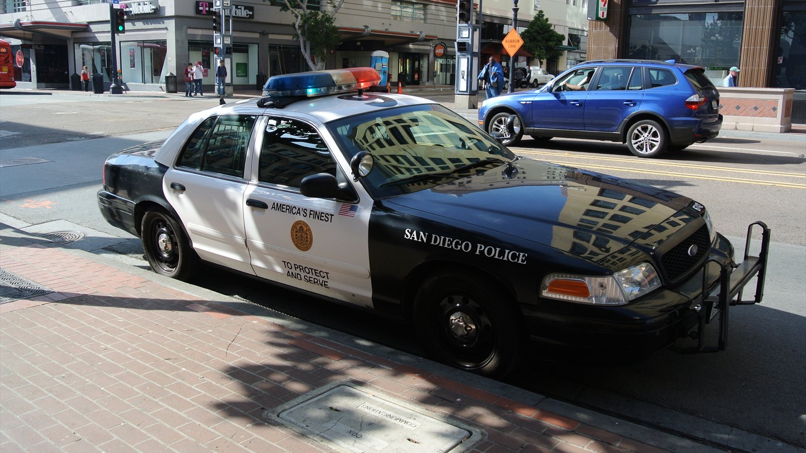 A black-and-white San Diego Police Department patrol car is parked at a downtown curb.