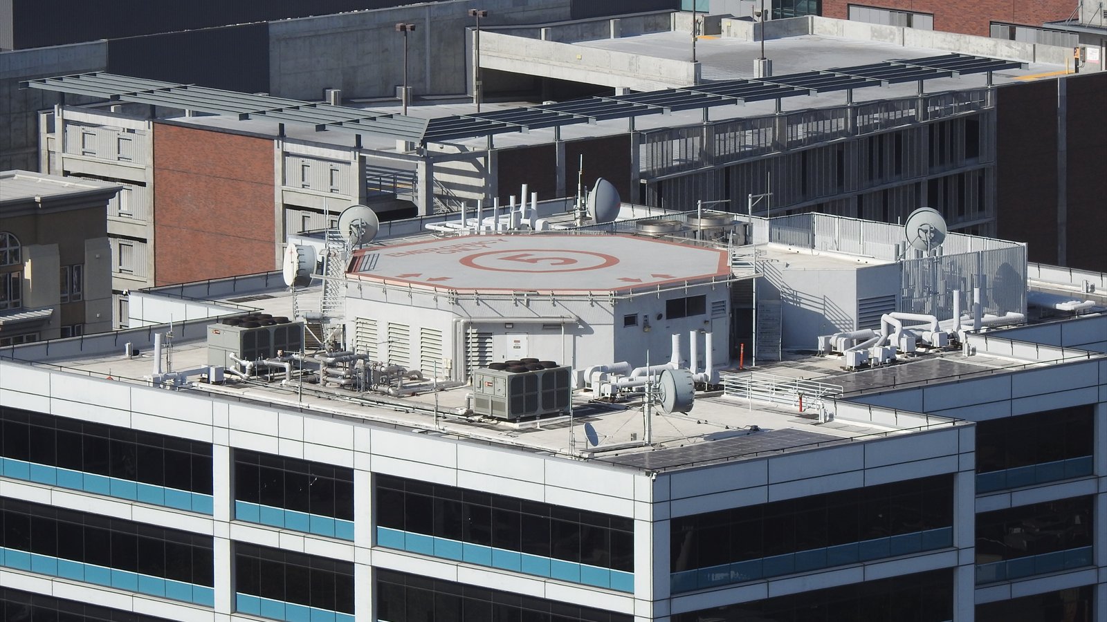 The rooftop heliport and upper stories of San Diego Police Headquarters rise above downtown buildings.