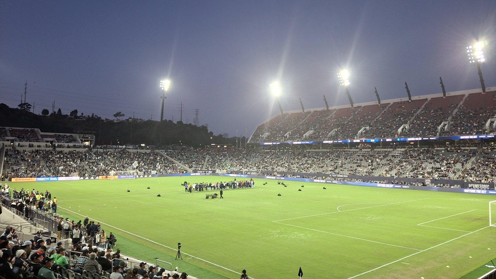 Snapdragon Stadium's seating bowl and green football field are viewed from the stands.