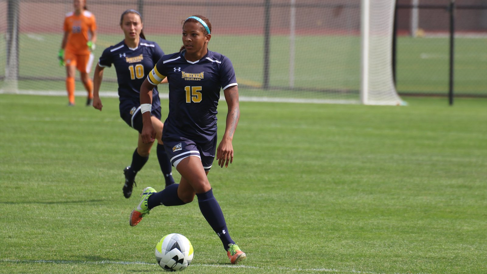 A University of Northern Colorado women's soccer player dribbles the ball during a match.