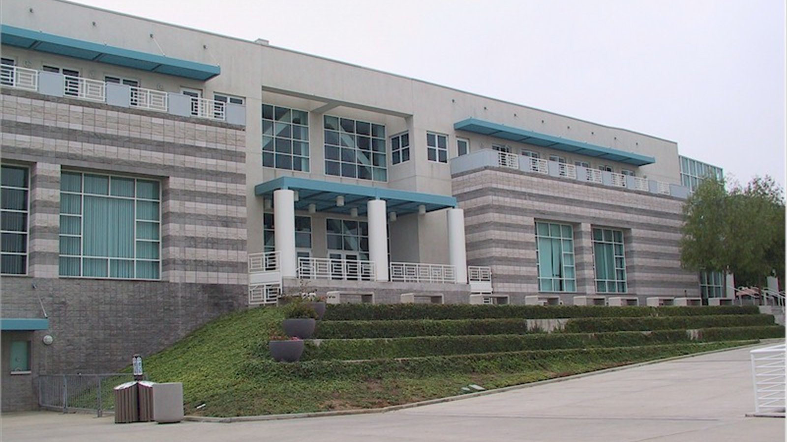 The gray-and-white exterior of UC San Diego's LionTree Arena rises above landscaped terraces and a wide walkway.